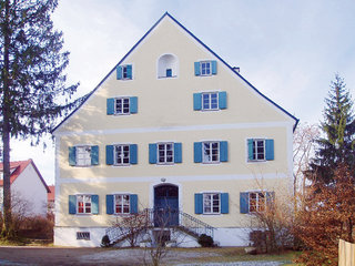 Gelbes Landjugendhaus mit blauen Fensterläden