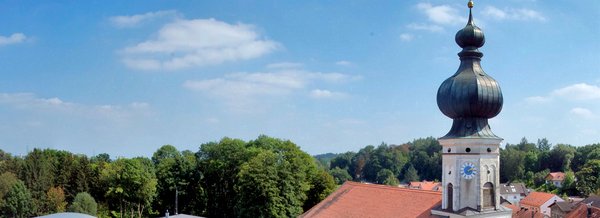 [Translate to English:] Taufkirchener Kirchturm mit blauem Himmel